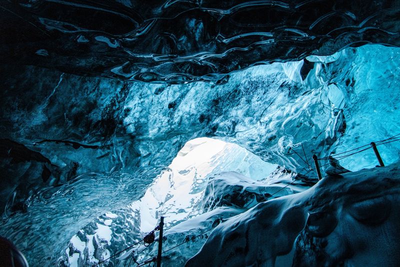 Light shining through the blue walls of an ice cave inside a glacier
